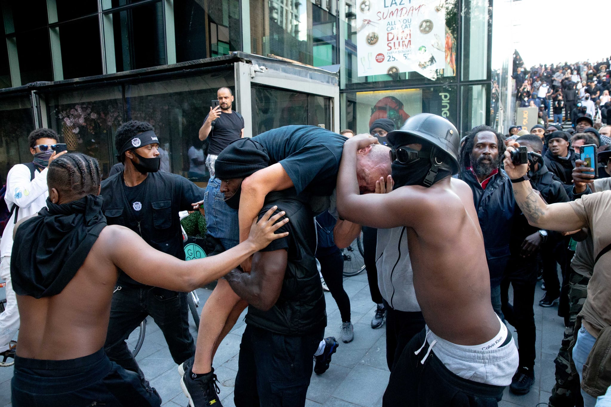 LONDON, UNITED KINGDOM - JUNE 13: A group of men including Patrick Hutchinson (carrying the man) help an injured man away after he was allegedly attacked by some of the crowd of protesters on the Southbank near Waterloo station on June 13, 2020 in London, United Kingdom. Following a social media post by the far-right activist known as Tommy Robinson, members of far-right linked groups have gathered around statues in London. Several statues in the UK have been targeted by Black Lives Matter protesters for their links to racism and the slave trade. (Photo by Luke Dray/Getty Images)