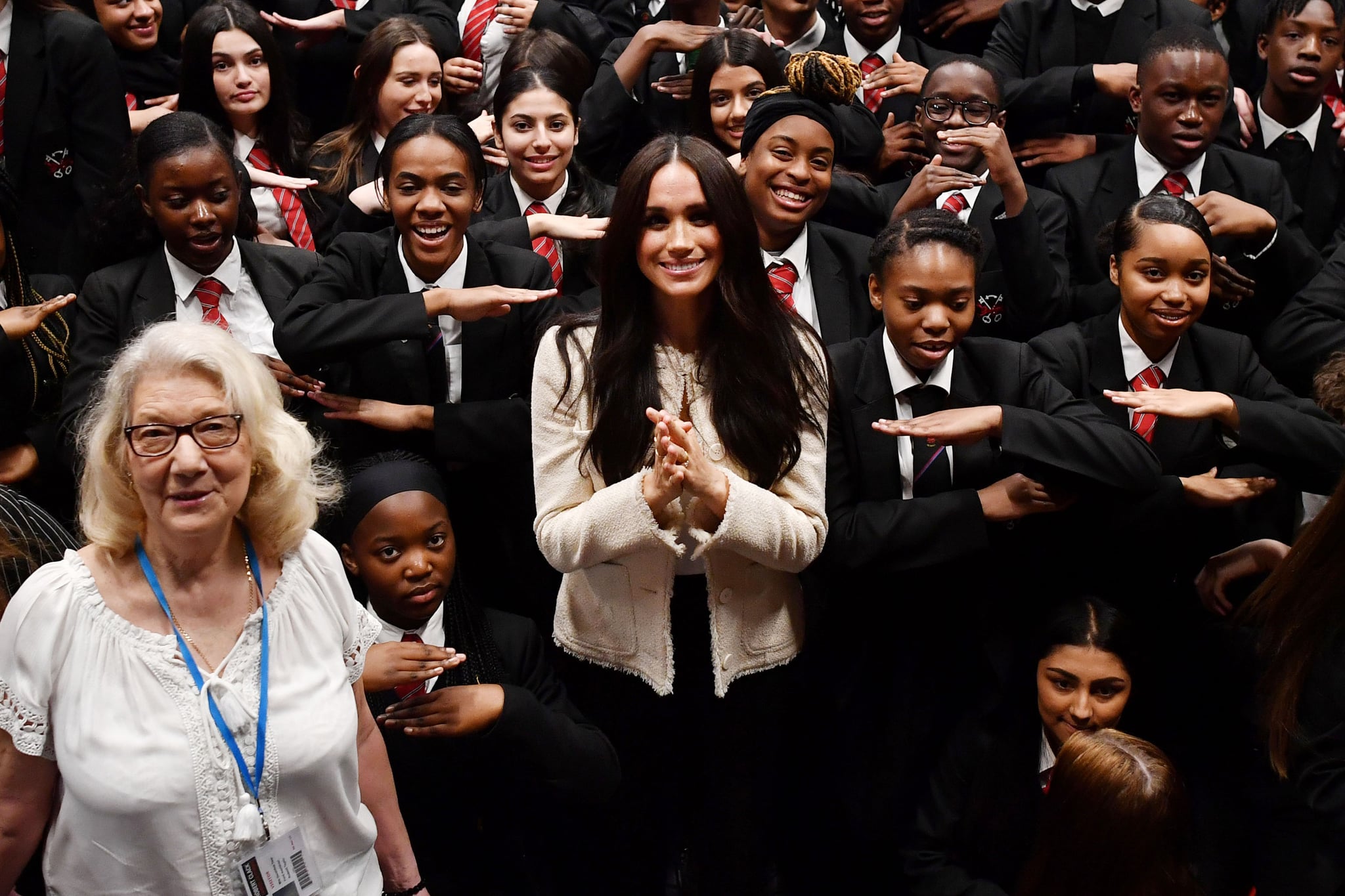LONDON, ENGLAND - MARCH 06: (EDITOR'S NOTE: Alternative crop of image #1205706931) Meghan, Duchess of Sussex poses with school children making the 'Equality' sign following a school assembly during a visit to Robert Clack School in Dagenham to attend a special assembly ahead of International Women's Day (IWD) held on Sunday 8th March, on March 6, 2020 in London, England.   (Photo by Ben Stansall-WPA Pool/Getty Images)