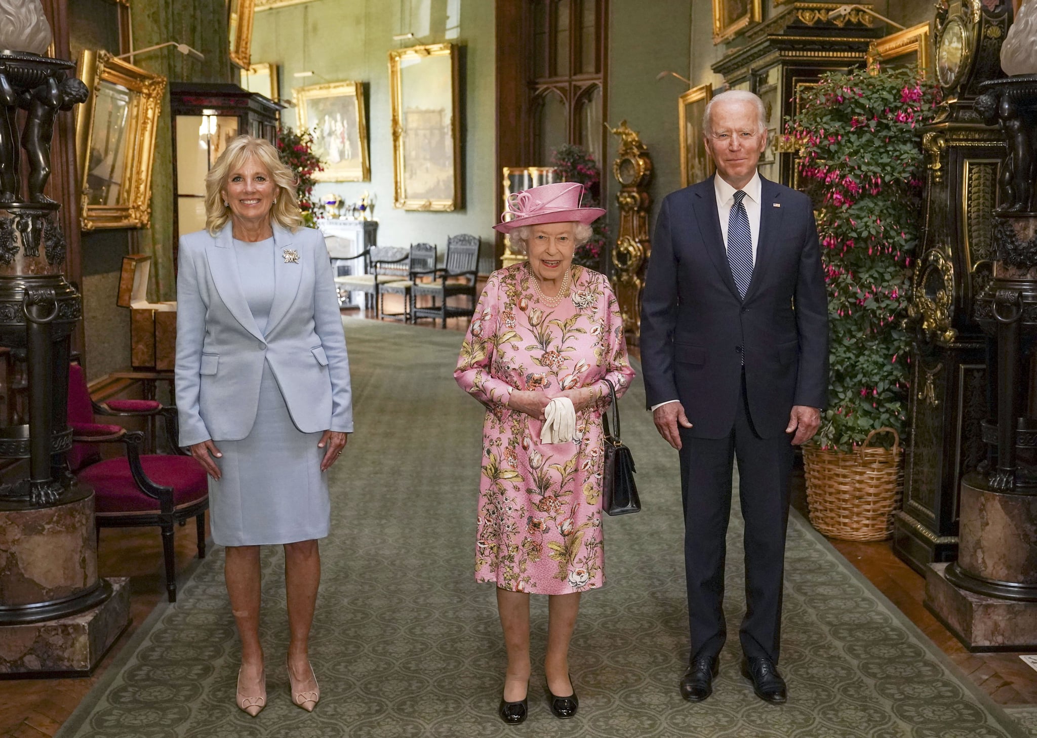 WINDSOR, ENGLAND - JUNE 13: Queen Elizabeth II (C) with US President Joe Biden and First Lady Jill Biden in the Grand Corridor during their visit to Windsor Castle on June 13, 2021 in Windsor, England. Queen Elizabeth II hosts US President, Joe Biden and First Lady Dr Jill Biden at Windsor Castle. The President arrived from Cornwall where he attended the G7 Leader's Summit and will travel on to Brussels for a meeting of NATO Allies and later in the week he will meet President of Russia, Vladimir Putin. (Photo by Steve Parsons - WPA Pool/Getty Images)