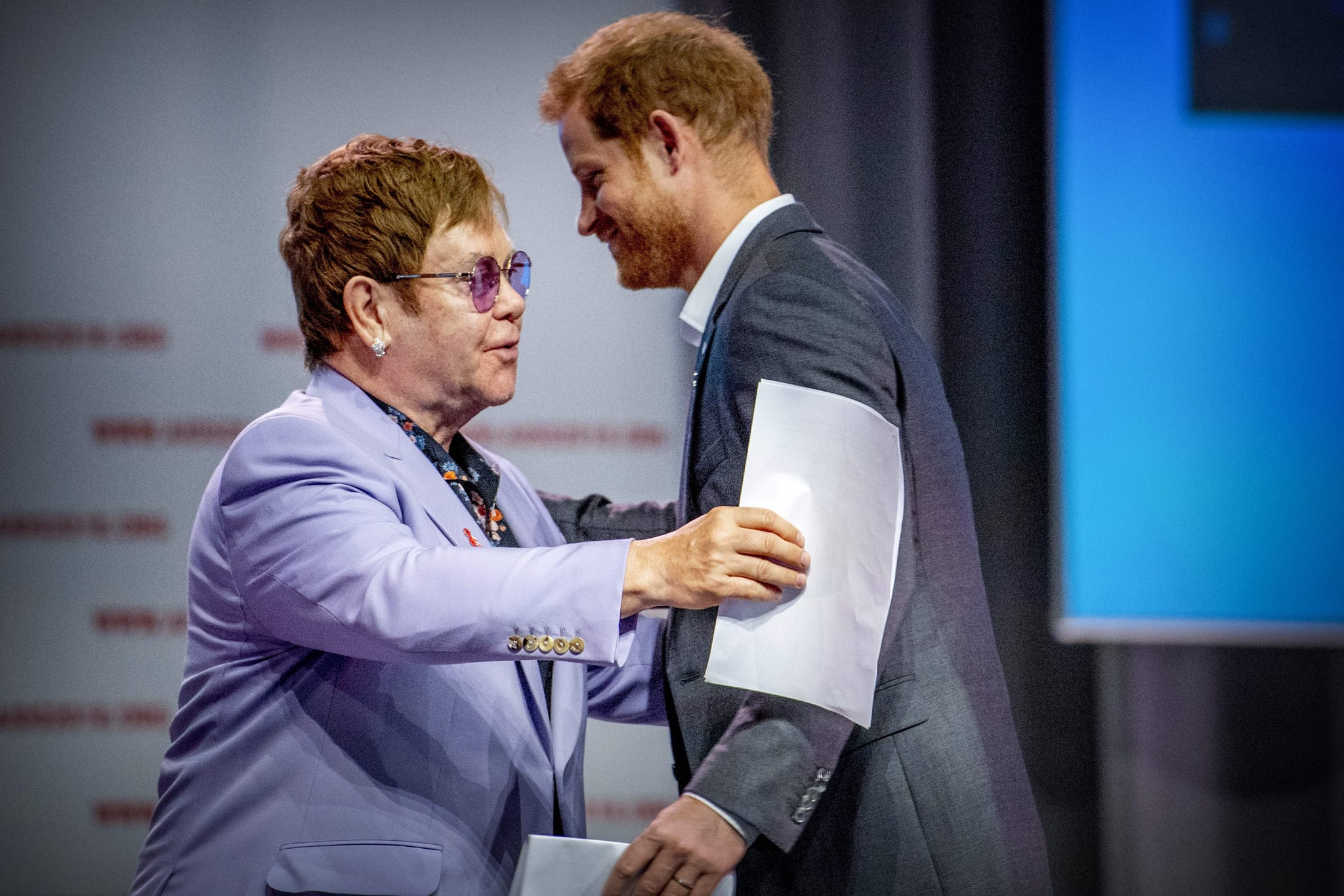 British Prince Harry (L) and sir Elton John attend a session about the Elton John Aids Fund on the second day of the Aids2018 conference, in Amsterdam on July 24, 2018. - From 23 to July 27, thousands of delegates -- researchers, campaigners, activists and people living with the killer virus -- attend the 22nd International AIDS Conference amid warnings that
