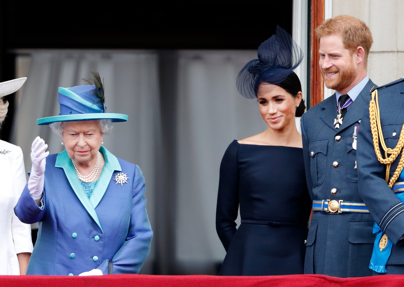 LONDON, UNITED KINGDOM - JULY 10: (EMBARGOED FOR PUBLICATION IN UK NEWSPAPERS UNTIL 24 HOURS AFTER CREATE DATE AND TIME) Queen Elizabeth II, Meghan, Duchess of Sussex and Prince Harry, Duke of Sussex watch a flypast to mark the centenary of the Royal Air Force from the balcony of Buckingham Palace on July 10, 2018 in London, England. The 100th birthday of the RAF, which was founded on on 1 April 1918, was marked with a centenary parade with the presentation of a new Queen